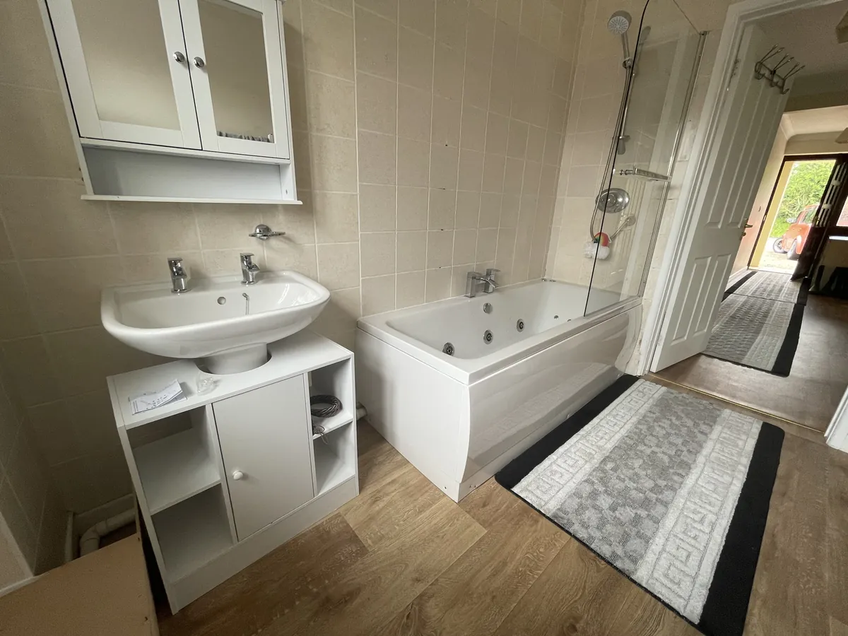 Finished bathroom near Exeter Airport with a new whirlpool bath, vanity basin and shower