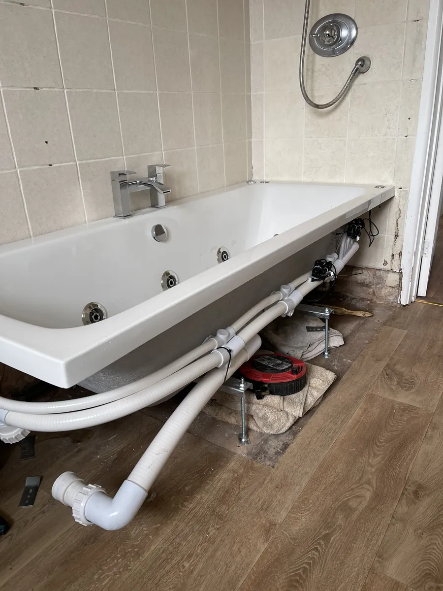 Whirlpool bath in position with its pump and pipework, bathroom refit near Exeter Airport