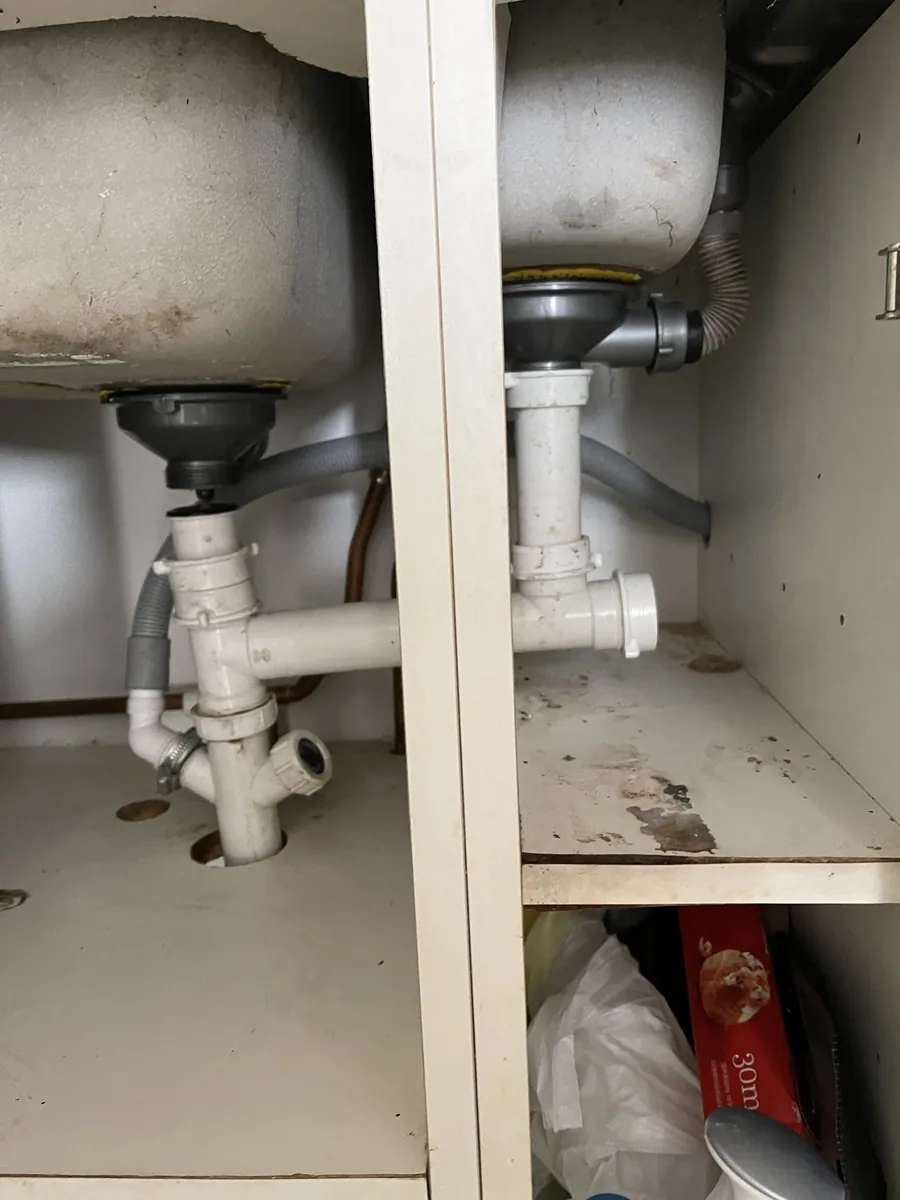 Old kitchen sink waste pipework under a sink in Exeter