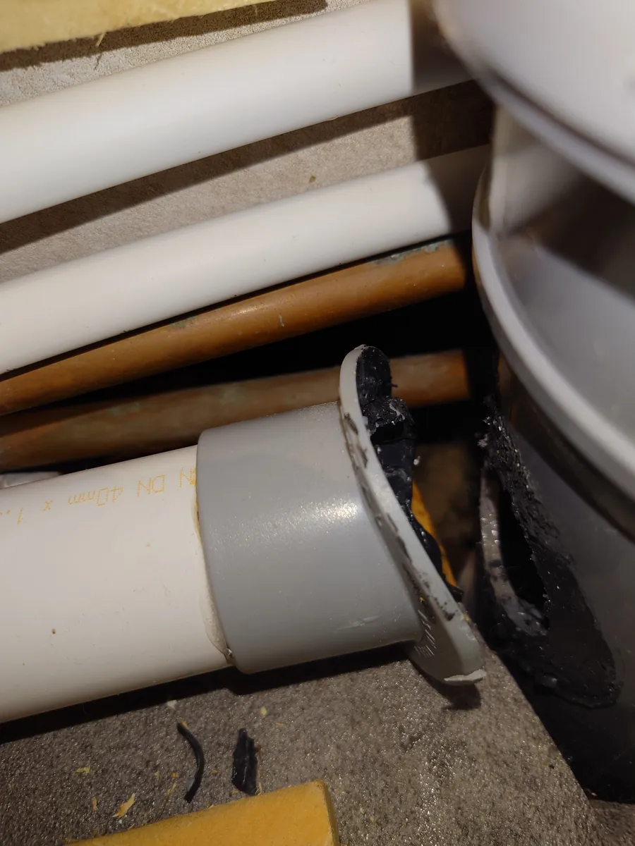 Leaking soil pipe joint bodged with sealant, found during a repair in Exeter