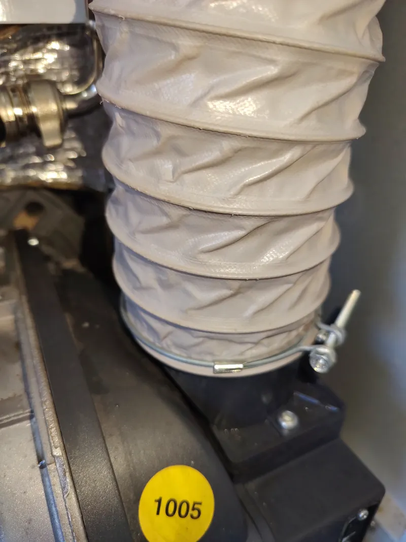 Flexible grey combustion air duct clipped to the air intake of a Riello burner on a Grant Vortex Pro oil boiler