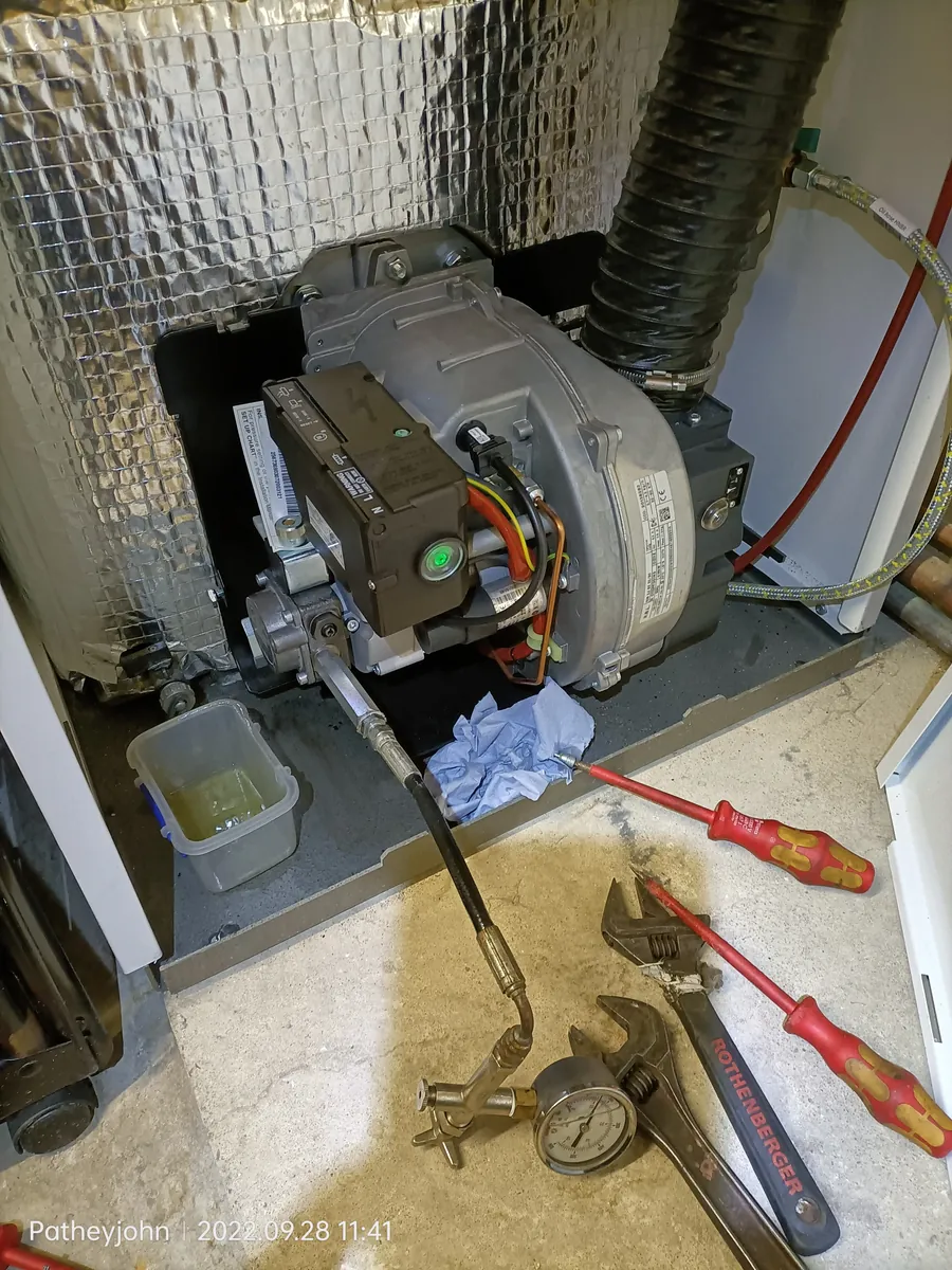 Riello oil burner removed and on the floor for cleaning during a boiler service in Exeter