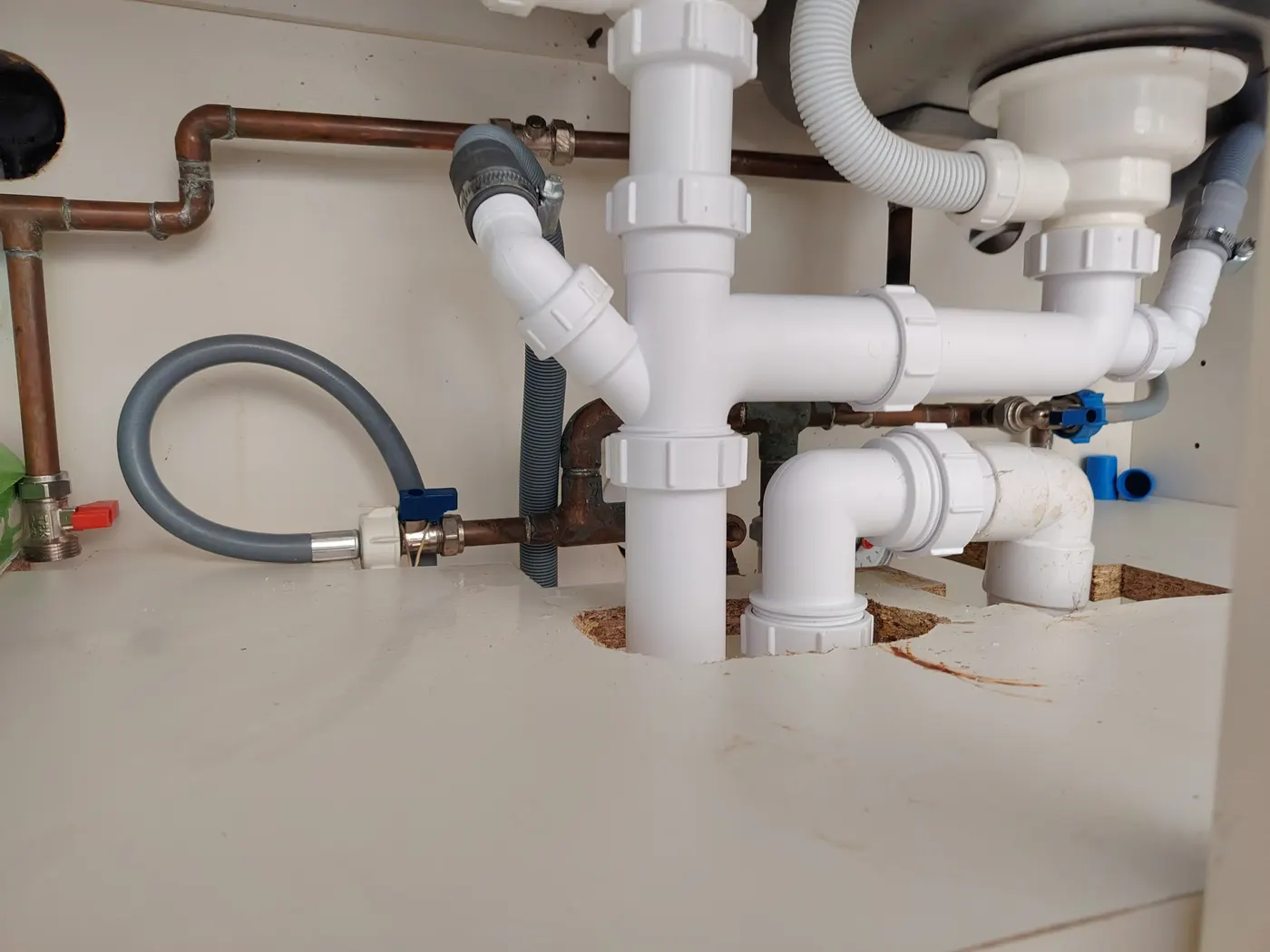 Bowl and a half sink waste kit being assembled under the kitchen sink